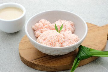 Kue Putu Mayang is traditional Indonesian snack made from rice flour strands curled up into a ball, served with coconut milk and palm sugar. Selected focus.
