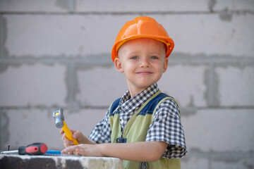 Child play with supplies, tools saw, hammer, screwdriver, helmet, builder, carpenter. Kids playing...