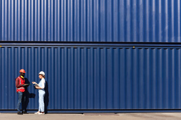 Two workers wear safety vest and helmet discus at logistic shipping cargo container yard workplace....