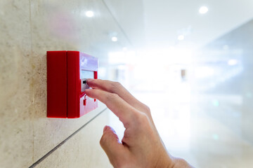 Hand pushing the fire alarm button