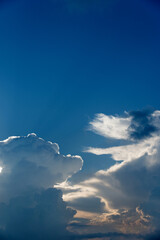 Fototapeta na wymiar Sun rays from behind clouds on blue sky