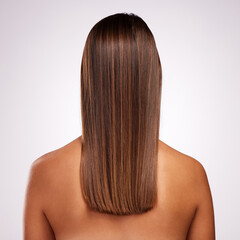 Naklejka premium Perfectly layered. Studio shot of an unrecognizable young woman standing with her back facing the camera to show off her hair against a grey background.