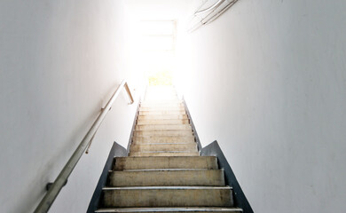 Staircase going up to white light door