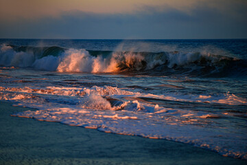 Sea waves background. Sunset with large yellow sun under the sea surface. Waves splashes.