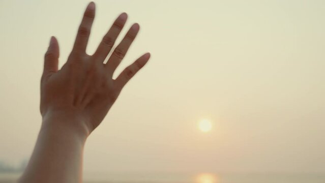 Woman waving hand say goodbye or parting with sunset alone on the seaside, Time to go farewell