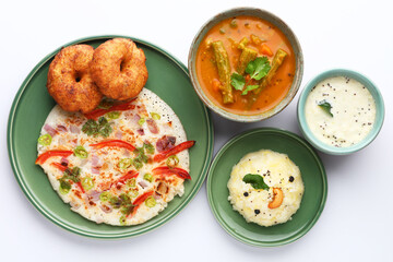 South Indian food like Uttapam, Wada, vada, Pongal, Sambar with chutneys, selective focus