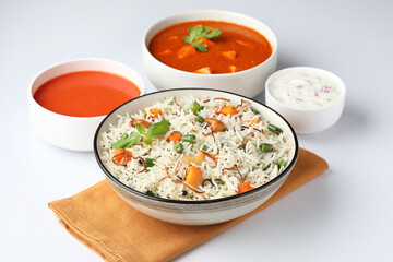 Indian food Vegetable biryani with Paneer butter masala, tomato soup and Curd raita