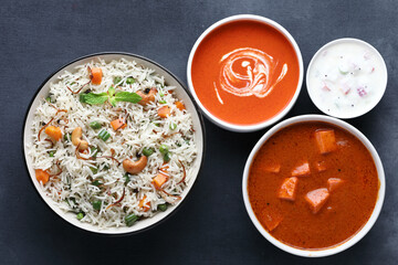Indian food Vegetable biryani with Paneer butter masala, tomato soup and Curd raita