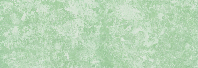 pastel light green stucco wall with cracks and peeling paint flakes