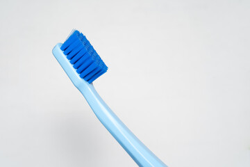 part of blue toothbrush. Toothbrush closeup on white background.