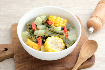 Sayur asam, sayur asem or tamarind soup is a popular traditional Indonesian soup. Common ingredients are chayote, long beans and corn with the addition of tamarind or bilimbi. Served in white bowl.
