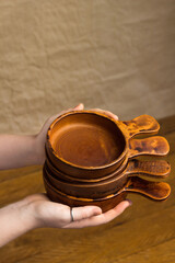 Vertical picture ceramic shop assortment. Close up Woman showing handmade cocotte dishes, demonstrating products