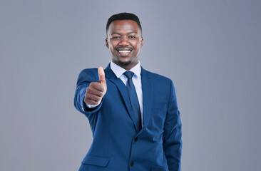 Youve got my approval. Cropped portrait of a handsome young businessman giving you a thumbs up in studio against a grey background.