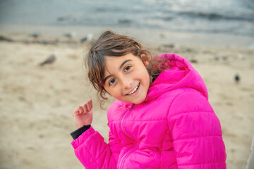 Happy young girl smiling on the beach in winter.