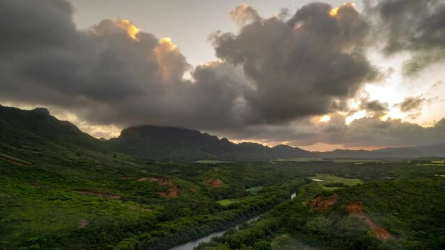 Beautiful sunset of clouds boiling across a golden sky, Kauai, Hawaii, Menehune Fishpond, aerial hyperlapse