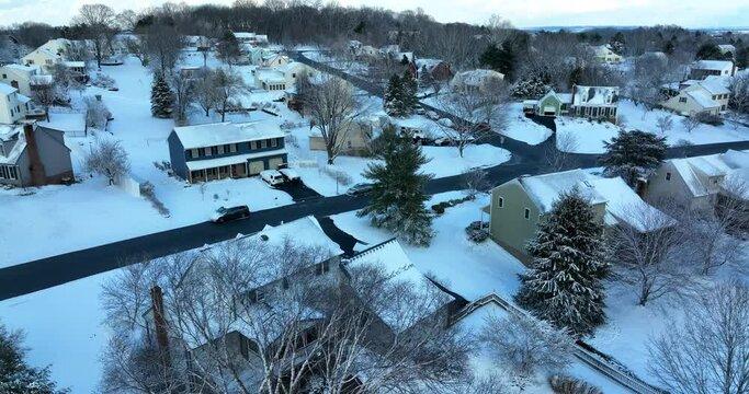 Backyard aerial view of winter snow. Duplex and Cape Cod single family homes in USA.