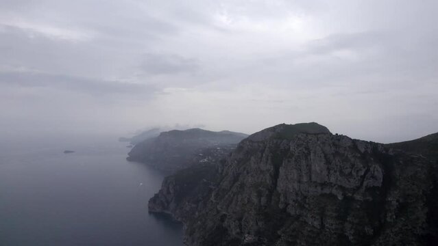 Drone video over the Amalfi Coast near Positano with frontal plane advancing to the top of the cliff towards Torca.
Clouds and the greatness of the landscape and the cliffs can be seen.
