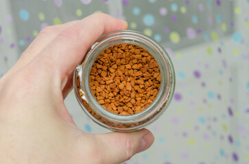 freeze-dried coffee in a glass jar in hand