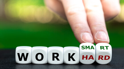 Hand turns dice and changes the expression "work hard" to "work smart".