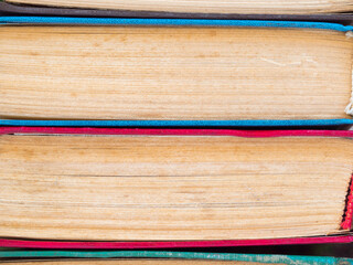 Books in the stack -background. Books and reading are necessary for self-improvement, gaining knowledge and success in career, business and personal life. Texture of various books stacked