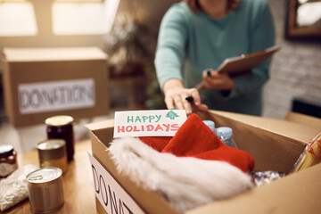 Close up of woman prepares food donation boxes during Christmas holidays.