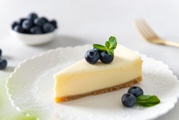 Homemade vanilla cheesecake with blueberry and mint on white background - healthy organic summer dessert pie cheesecake. Cheesecake New York. Side view, close up. Menu, recipe, confectionery