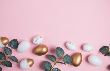 Easter eggs with green eucalyptus branches on a pink background. Holiday concept. Happy Easter greeting card