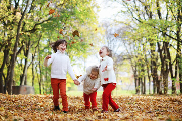 Fototapeta premium Children for a walk in the autumn park. Leaf fall in the park. Family. Fall. Happiness.
