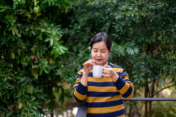 Elderly asian woman drinking coffee at home,Happy and smiling,Health care senior insurance concept