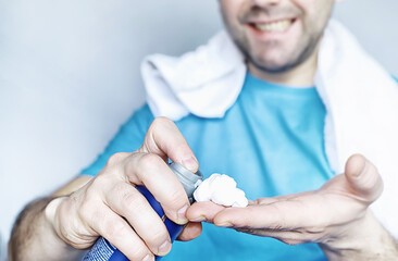 A man shaves in front a mirror. Shaving foam. Disposable razor.