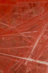 many glass pipette tips with red background