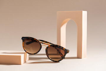 Trendy sunglasses still life in minimal stile. Womens Tortoiseshell frame sunglasses on beige...