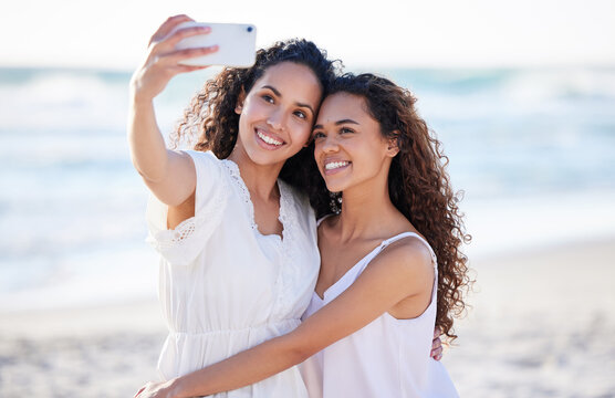 How lucky I am to have her in my life. Shot of two young women taking selfies at the beach.