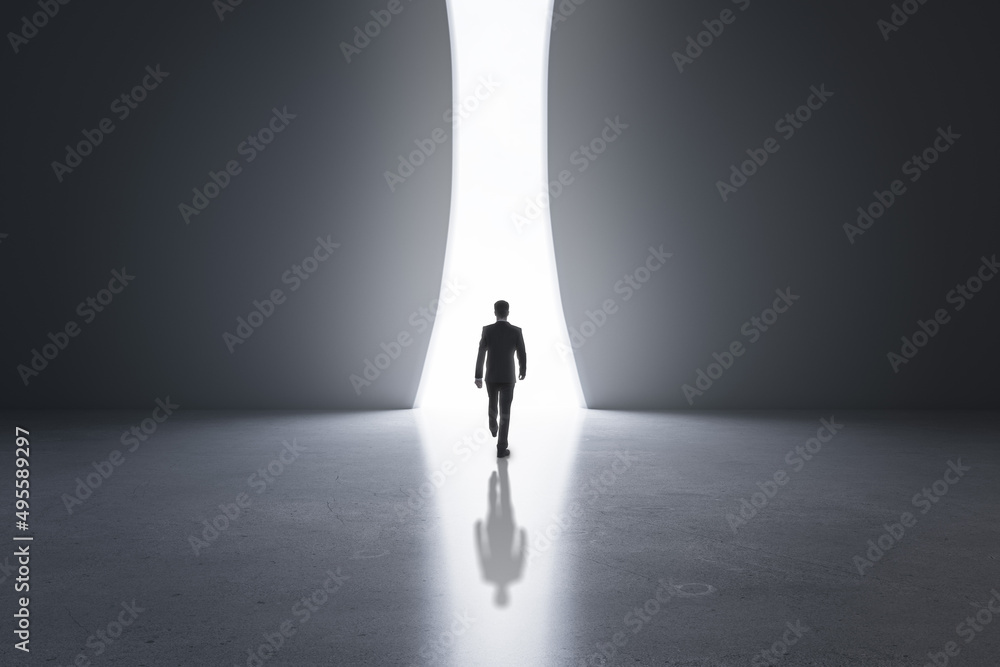 Poster back view of young businessman in concrete interior with bright opening window and mock up place on 