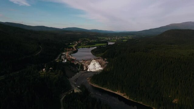 Aerial view around the Nedre Fiskumfoss Kraftverk dam, in cloudy Trondelag, Norway - circling, drone shot