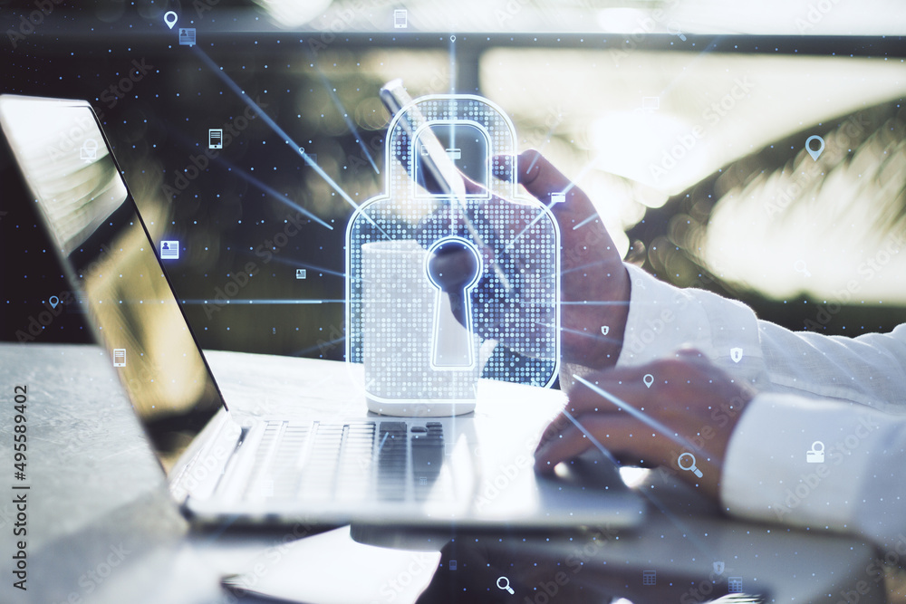 Poster close up of businessman hand using laptop and smartphone with creative glowing web security padlock 