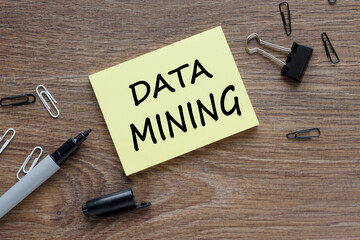 data mining text on yellow sticker near black pen
