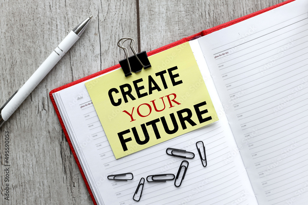 Poster create your future. text on yellow sticky note on open notepad