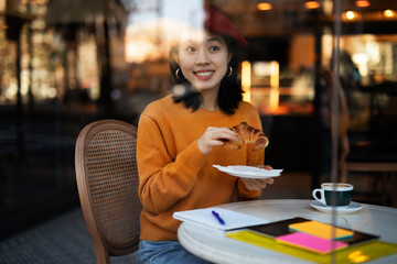 Beautiful Chinese woman drinking coffee in cafe. Young smiling woman enjoy in restaurant..
