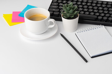 Office desk with laptop, blank notebook and coffee cup