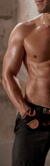 Fototapeta premium Portrait of strong athletic male at the gym, close up abs muscles, smiling