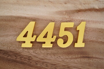 Golden Arabic numerals on a real brown and white wooden floor number 4451