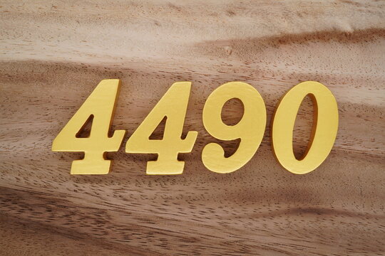 Golden Arabic numerals on a real brown and white wooden floor number 4490