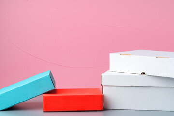 Set of cardboard boxes on pink background