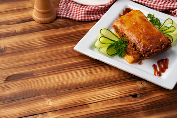 Tasty lasagne served on plate on wooden background