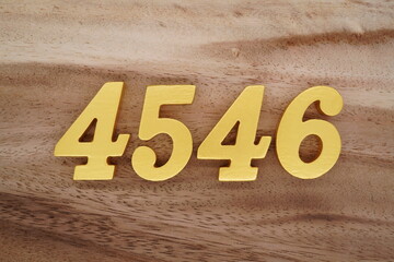 Golden Arabic numerals on a real brown and white wooden floor number 4546
