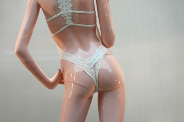 Female mannequin in underwear, back view. Lingerie store, white lace panties in a shop window