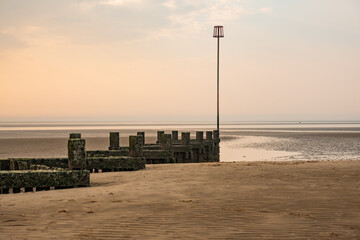 Obraz premium Wooden seaside breaker or groyne on Hunstanton beach on the North Norfolk coast at sunset