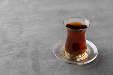Turkish tea in traditional glass on gray background