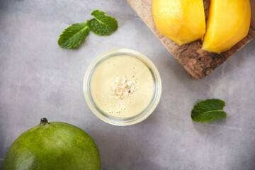A healthy lifestyle isnt about what you lose, its about what you gain. Overhead shot of a mango smoothie on a grey background.